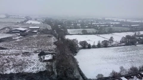 Flying over a patchwork of snow covered fields in winter Video stock 225468850
