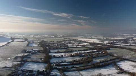 Flying over a patchwork of snowy fields in winter sunshine. Beautiful blue sky Video stock 226536220