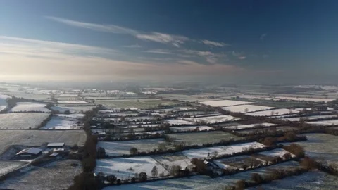 Flying over a patchwork of snowy fields in winter sunshine. Beautiful blue sky Video stock 226537815