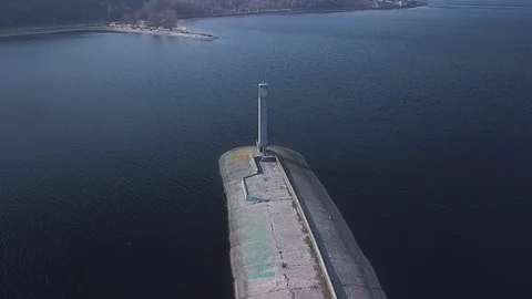 Flying over the pier with an abandoned lighthouse with flocks of seagulls Stock Footage 126701341