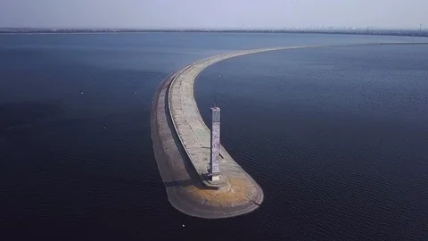 Flying over the pier with an abandoned lighthouse with flocks of seagulls Stock-Footage 126701554