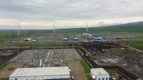 Flying over a power plant surrounded by windmills. Stock Footage 230237239