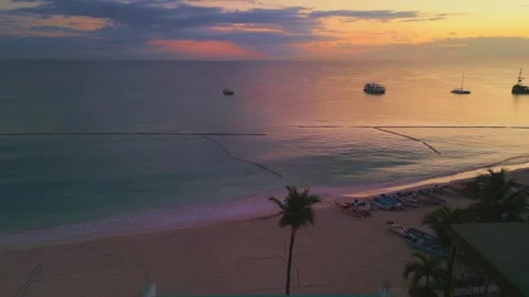 Flying over a Punta Cana beach hotel featuring stunning rooftop pool at sunrise Stock Footage 306798743