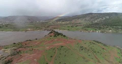 Flying over a red mountain along lake Salagou reveals the rainbow in the back Stock Footage 196300935