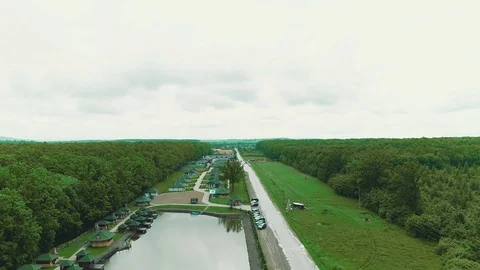 Flying over resort complex with same small houses, pool and pitch surrounded Stockbeeldmateriaal 124909816