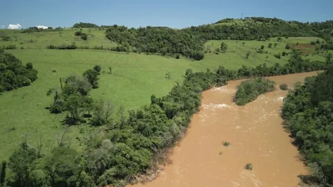Flying over a river amid green fields and trees. 4K. Drone. Aerial. Stock Footage 233219565