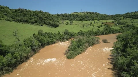 Flying over a river amid green fields and trees. 4K. Drone. Aerial. Video stock 233219629