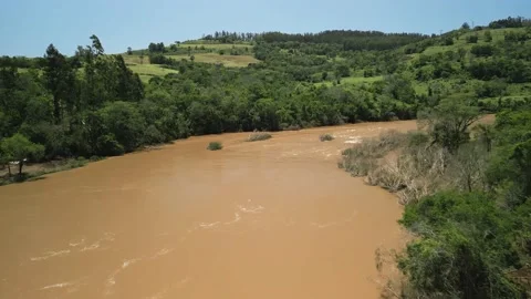 Flying over a river amid green fields and trees. 4K. Drone. Aerial. Stock Footage 233219631