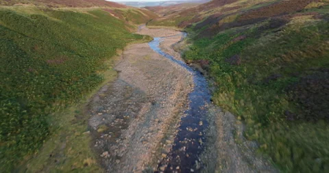 Flying over a river and heather moors in Yorkshire Dales Stock Footage 284051455