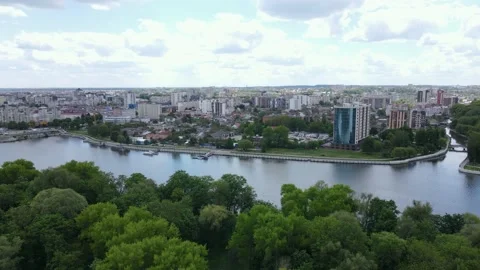 Flying over the river and park embankment in an urban area with roads and houses Stock Footage 154717680
