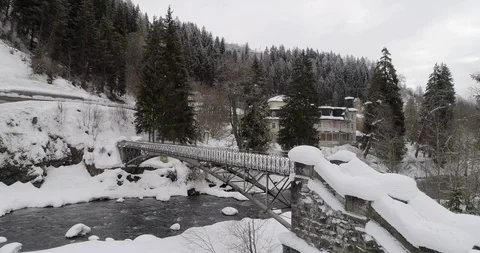 Flying over a river and a small bridge covered with snow Stockbeeldmateriaal 92524864