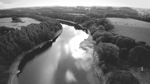 Flying over a river flowing through hills in countryside. stylish grayscale  4K. Stock Footage 68522976