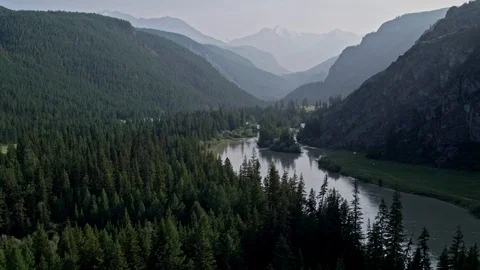 Flying over a river flowing through a forest a gorge. To the snowy mountains 4K Stock Footage 124743906