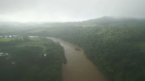 Flying over a river, forest and green fields amid dense fog. Low clouds. Stock Footage 233218346