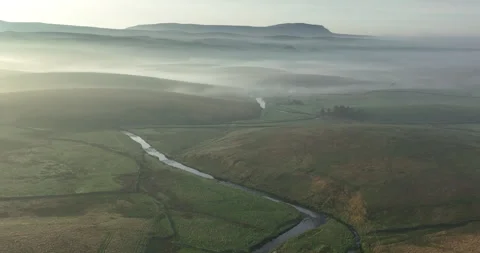 Flying over a river in a misty valley Video stock 248023693