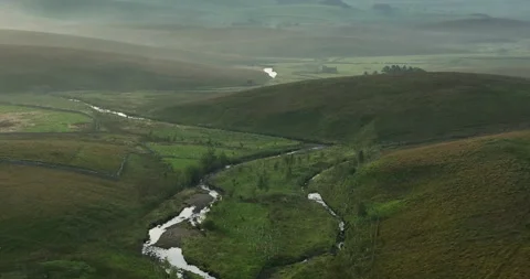 Flying over a river in a misty valley Stock Footage 250453920