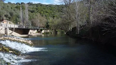 Flying over the river shrouded in trees, with small points of water running over Video stock 178601349