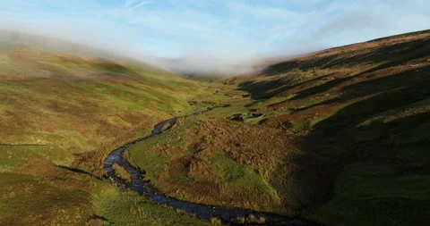 Flying over a river in a sunny and misty valley Stock Footage 296624095