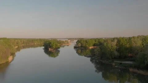 Flying over a river in the sunset with small islands and trees Stock Footage 232486923