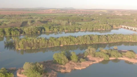 Flying over a river in the sunset with small islands and trees Stock Footage 232486965