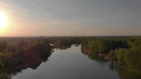 Flying over a river in the sunset with small islands and trees Stock Footage 232486990
