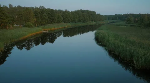 Flying over River Surrounded by Large Green Forest Stock Footage 68415143