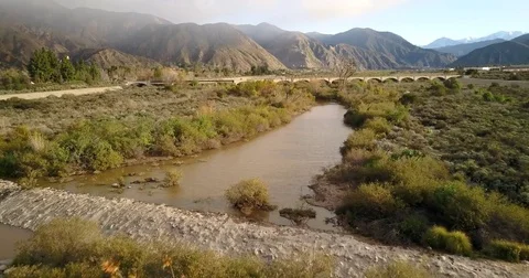 Flying over river trail and bridge Stock Footage 77703006