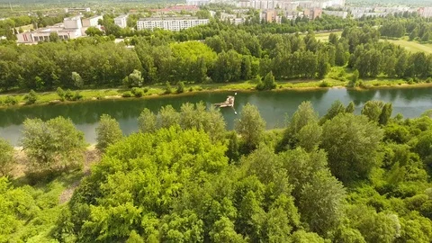 Flying over the river with trees on the background of the city. 動画素材 109461982