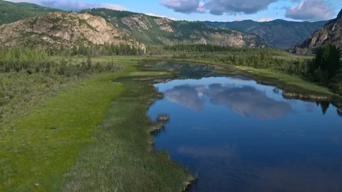 Flying over the river in the water reflected clouds background mountains 4k Stock Footage 124745745