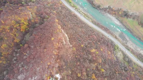 Flying over a road and a mountain river Stock Footage 170715759