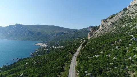 Flying Over the Road With a Beautiful View of the Mountains, the Sea and the Tow Stock Footage 125412273