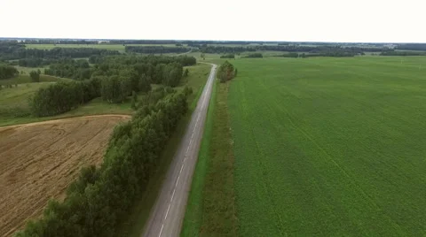 Flying over the road between fields of wheat and rye Stock Footage 67876020