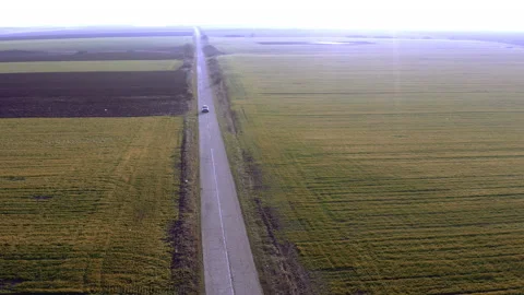Flying over a road between two large fields on a rainy day Stock Footage 150409479