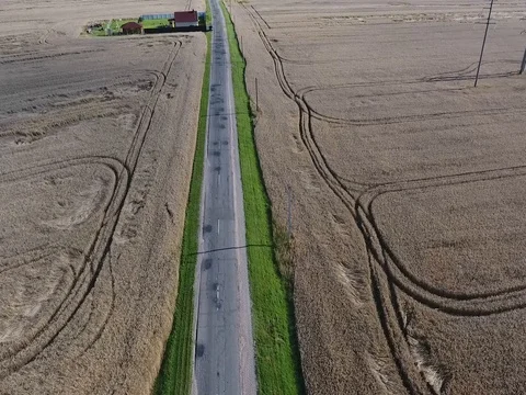Flying over the road between wheat fields Stock Footage 70348520