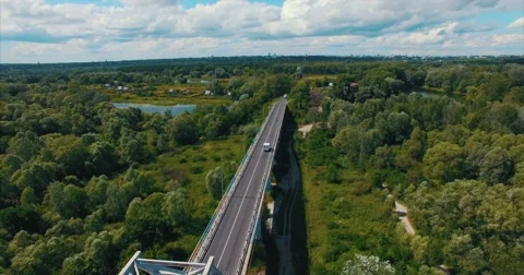 Flying Over the Road in the Forest and Lake Stock Footage 64924948