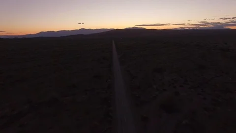 Flying over a road towards the sunset in the desert Stock Footage 106471574