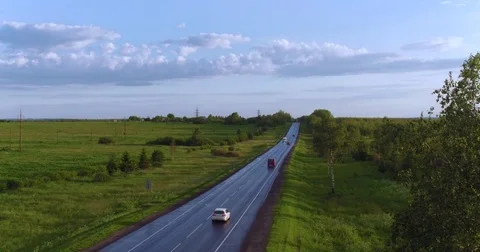Flying over road transport between the green field Stock Footage 77066156