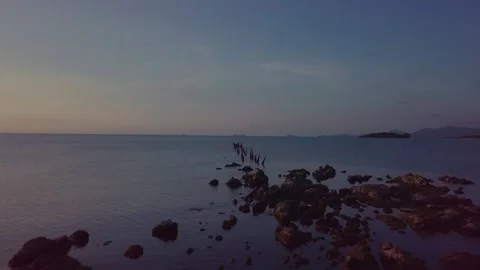 Flying over rocks and fragments of a pier in the sea Stock Footage 174031898