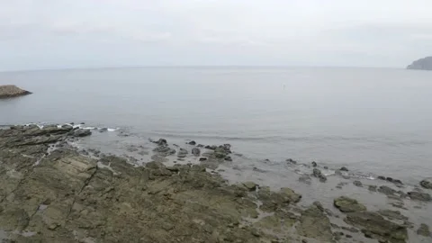 Flying over the rocks located along the beach of the Pacific Ocean Stock Footage 146755661