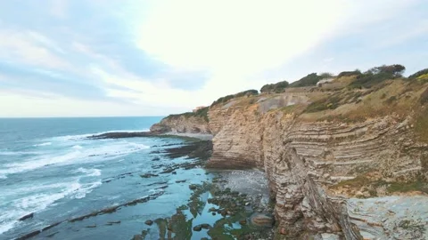 Flying Over Rocky Coastline alongside Cliffside at Saint Jean de Luz Stock Footage 212335353