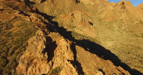 Flying over a rocky mountain peak on a drone. Stock Footage 237479879