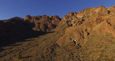 Flying over a rocky mountain peak on a drone. Stock Footage 237481585