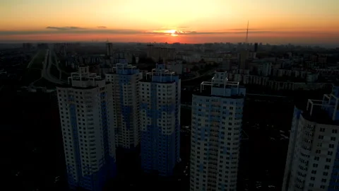 Flying over rooftops of high buildings on the outskirts of the city at sunset. Stock Footage 133646938