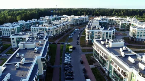 Flying over rooftops of modern apartment buildings, small town near forest Stock Footage 92665931