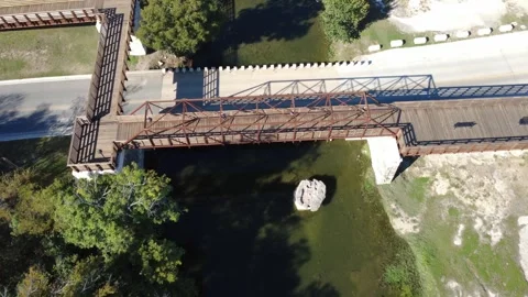 Flying over the Round Rock and new bridge in Chisolm Trail Crossing Park Stock Footage 321367063