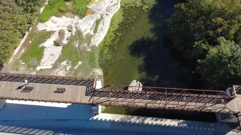 Flying over the Round Rock and new bridge in Chisolm Trail Crossing Park Stock Footage 321367068
