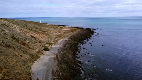 Flying over a rugged coast with a lighthouse Stock Footage 306946885