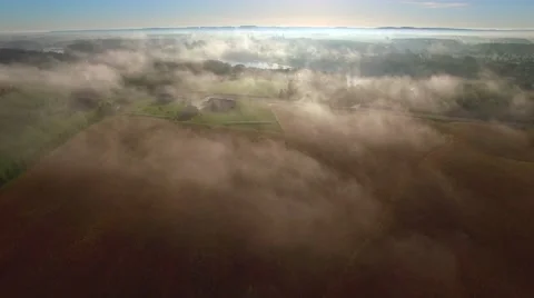 Flying over rural farms, fields, houses, on scenic foggy morning. Stock Footage