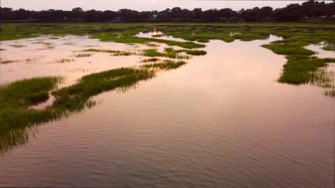 Flying over salt marsh with reflected sunset Stock-Footage 246695124