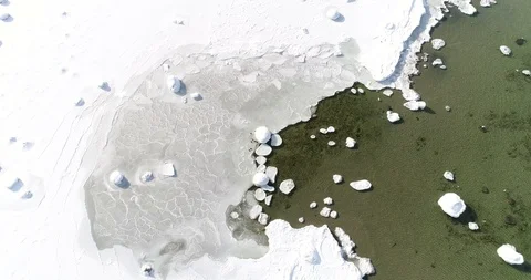 Flying over sandy beach with rolling waves and drifting ice floes in winter sea. Stock Footage 86476202
